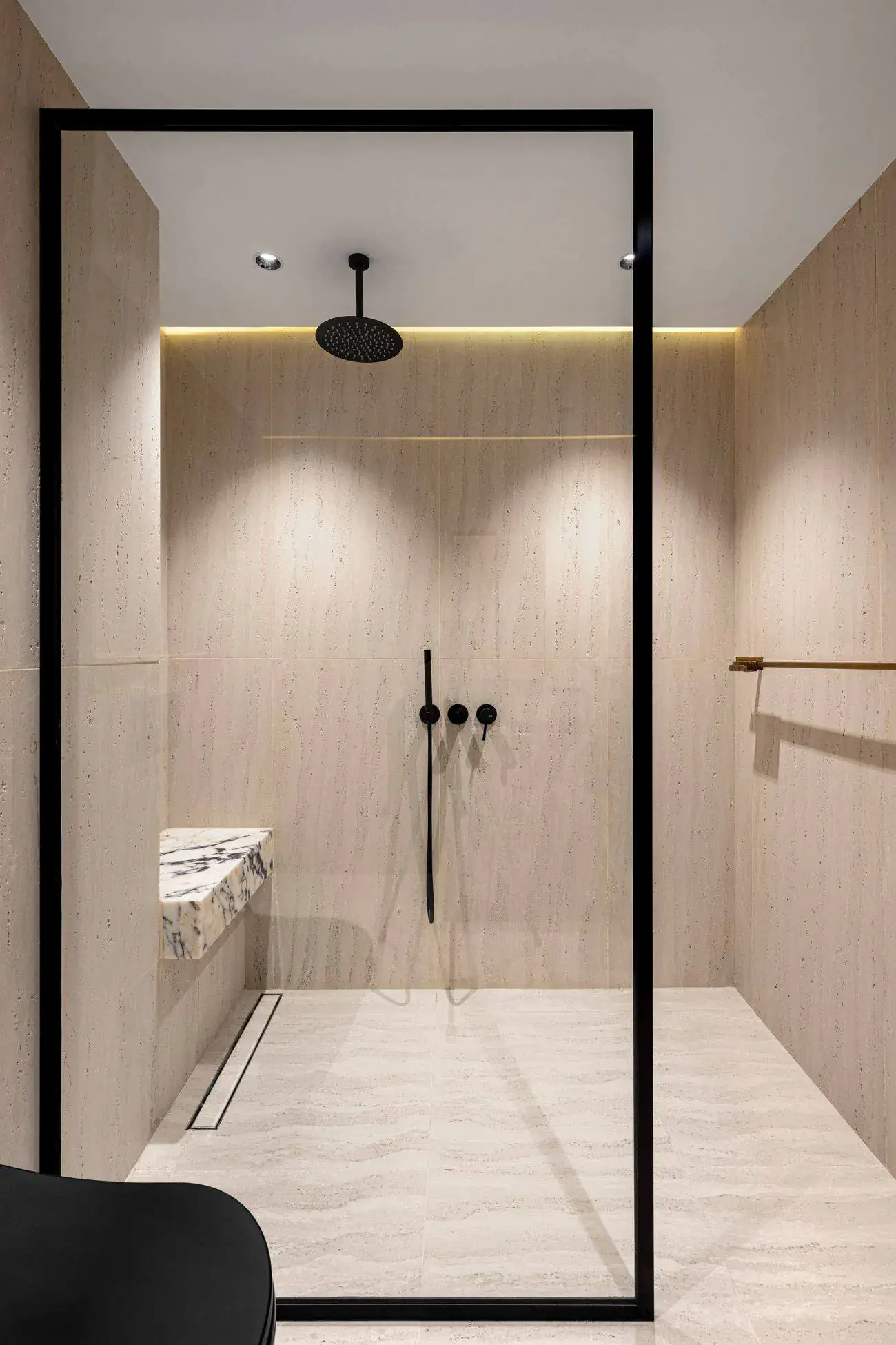 Bodengleiche Dusche mit Travertinfliesen und schwarzen Armaturen