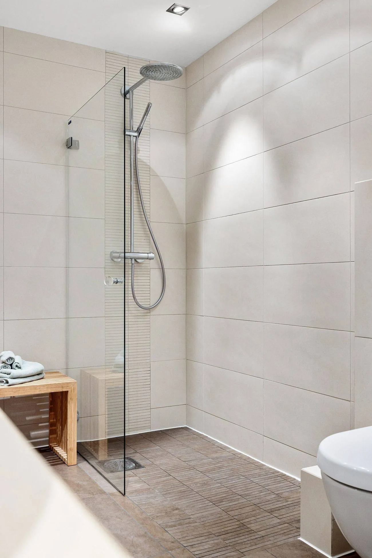 Bodengleiche Dusche mit Glaswand in einem hellen Bad