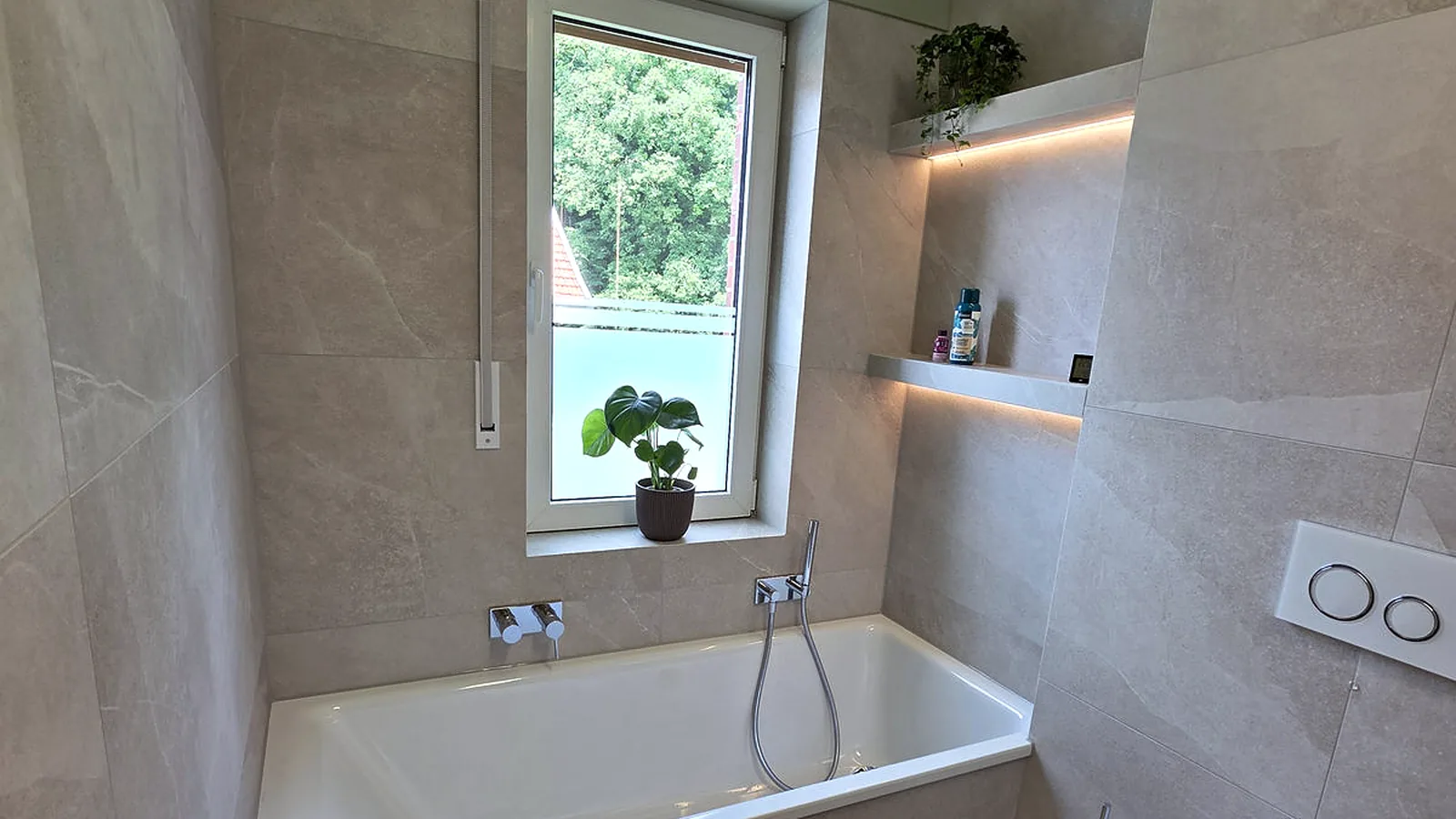 Bad mit Badewanne am Fenster, großformatig gefliest