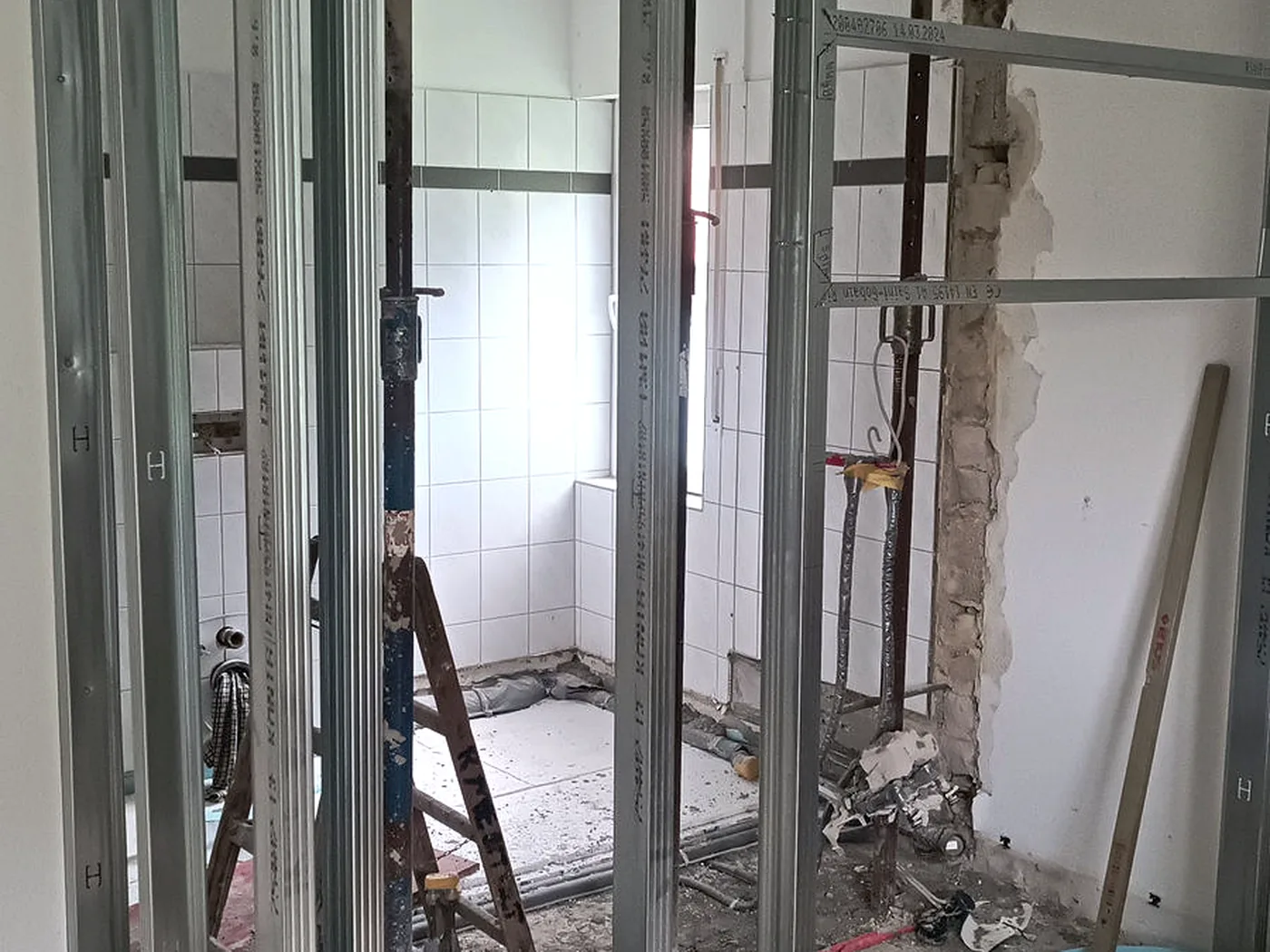 Metallständerwerk einer Vorwand im Bad, dahinter der Rückbau