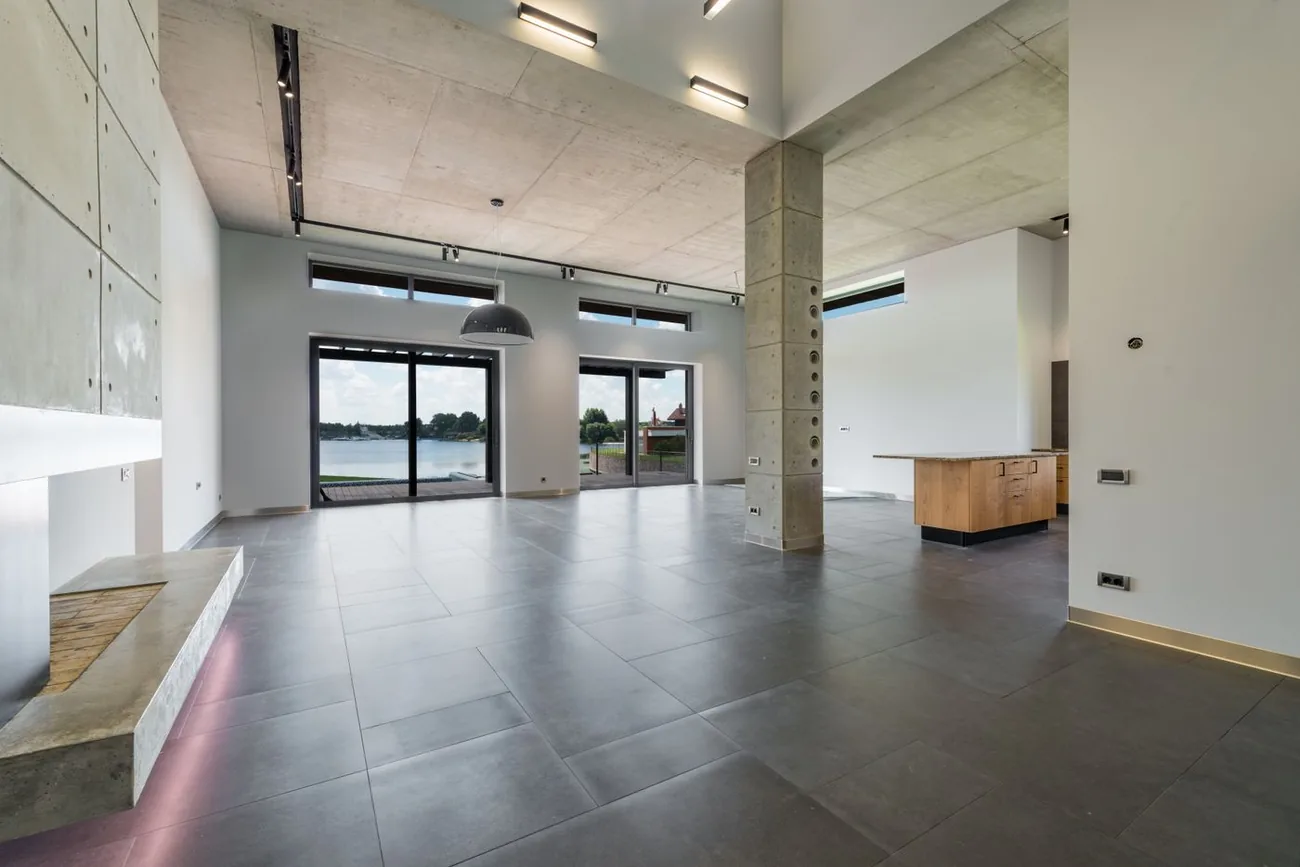 Neubau im Innenausbau mit großformatig gefliestem Boden und bodentiefen Fenstern