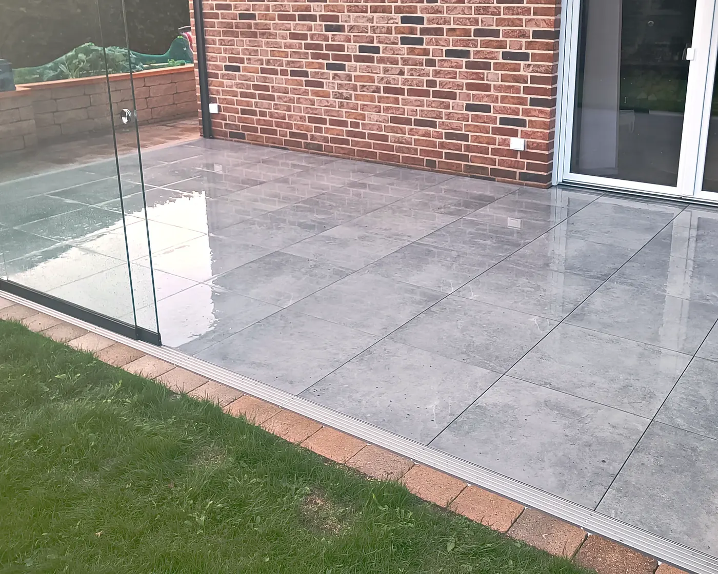 Fertig verlegte Großformatplatten auf der Terrasse unter dem Glasdach